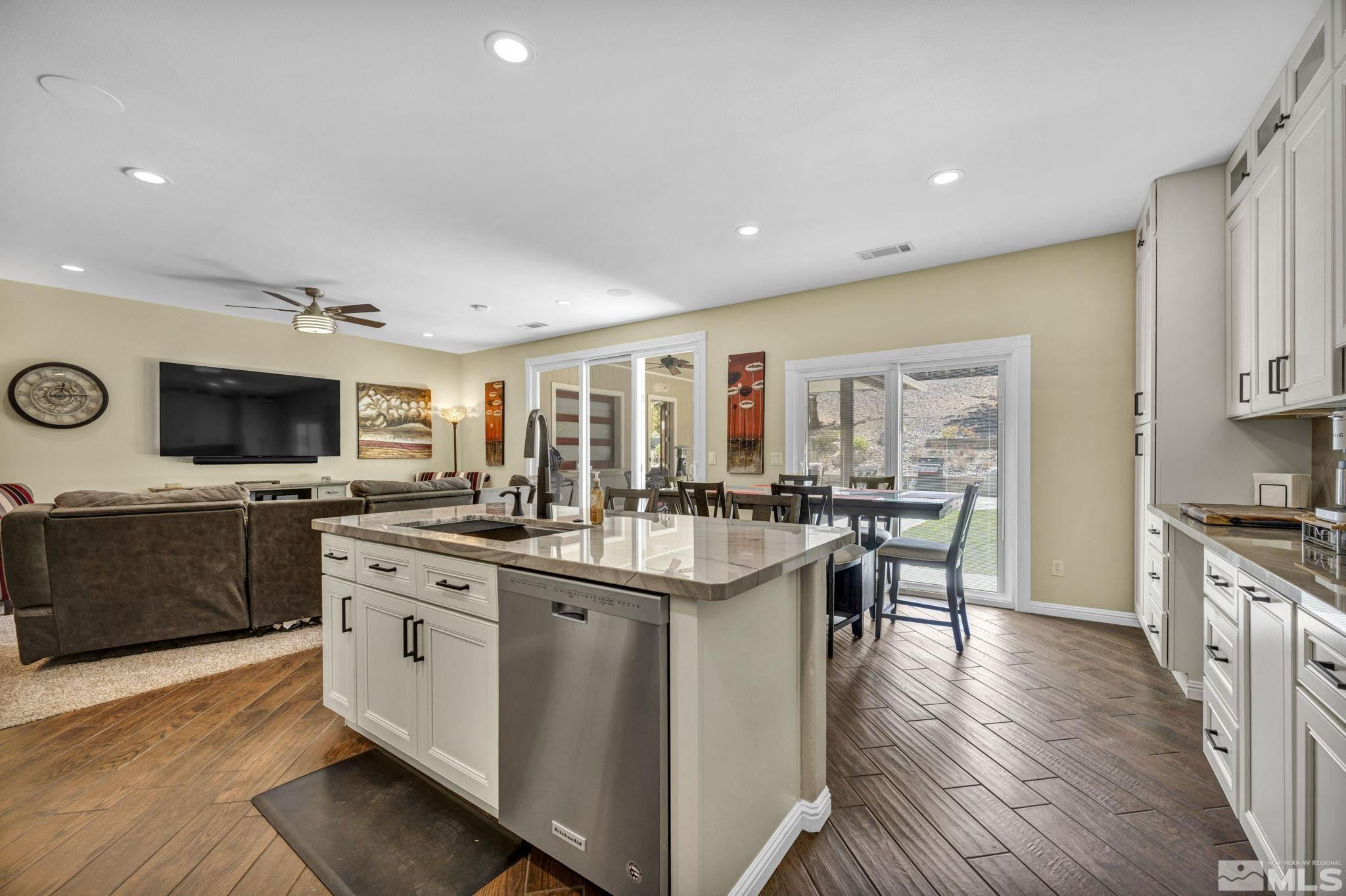 6015 Stillmeadow Drive Reno, NV 89502 - Photo 14 of 39 a kitchen with stainless steel appliances granite countertop a stove top oven a sink dishwasher and white cabinets with wooden floor