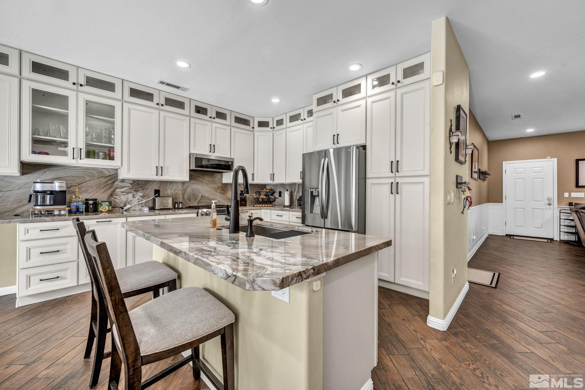 6015 Stillmeadow Drive Reno, NV 89502 - Photo 15 of 39 a kitchen with granite countertop a refrigerator stove microwave and cabinets