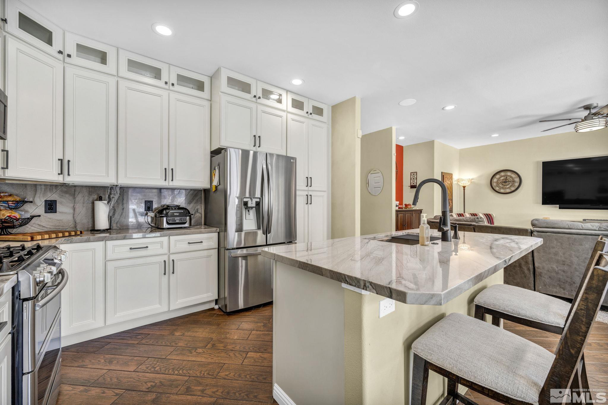 6015 Stillmeadow Drive Reno, NV 89502 - Photo 16 of 39 a kitchen with stainless steel appliances granite countertop a table chairs microwave and sink