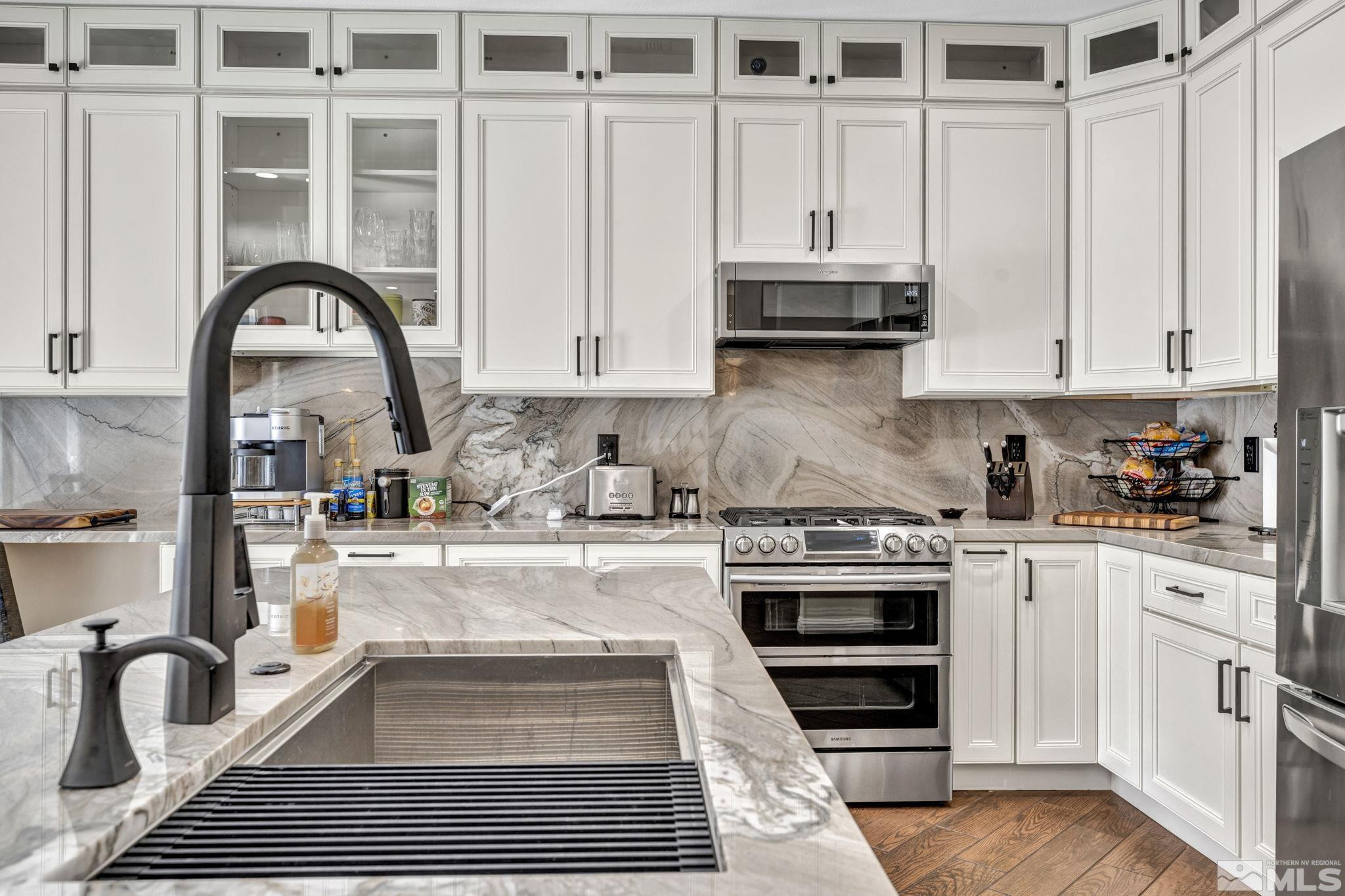 6015 Stillmeadow Drive Reno, NV 89502 - Photo 17 of 39 a kitchen with granite countertop a stove and white cabinets