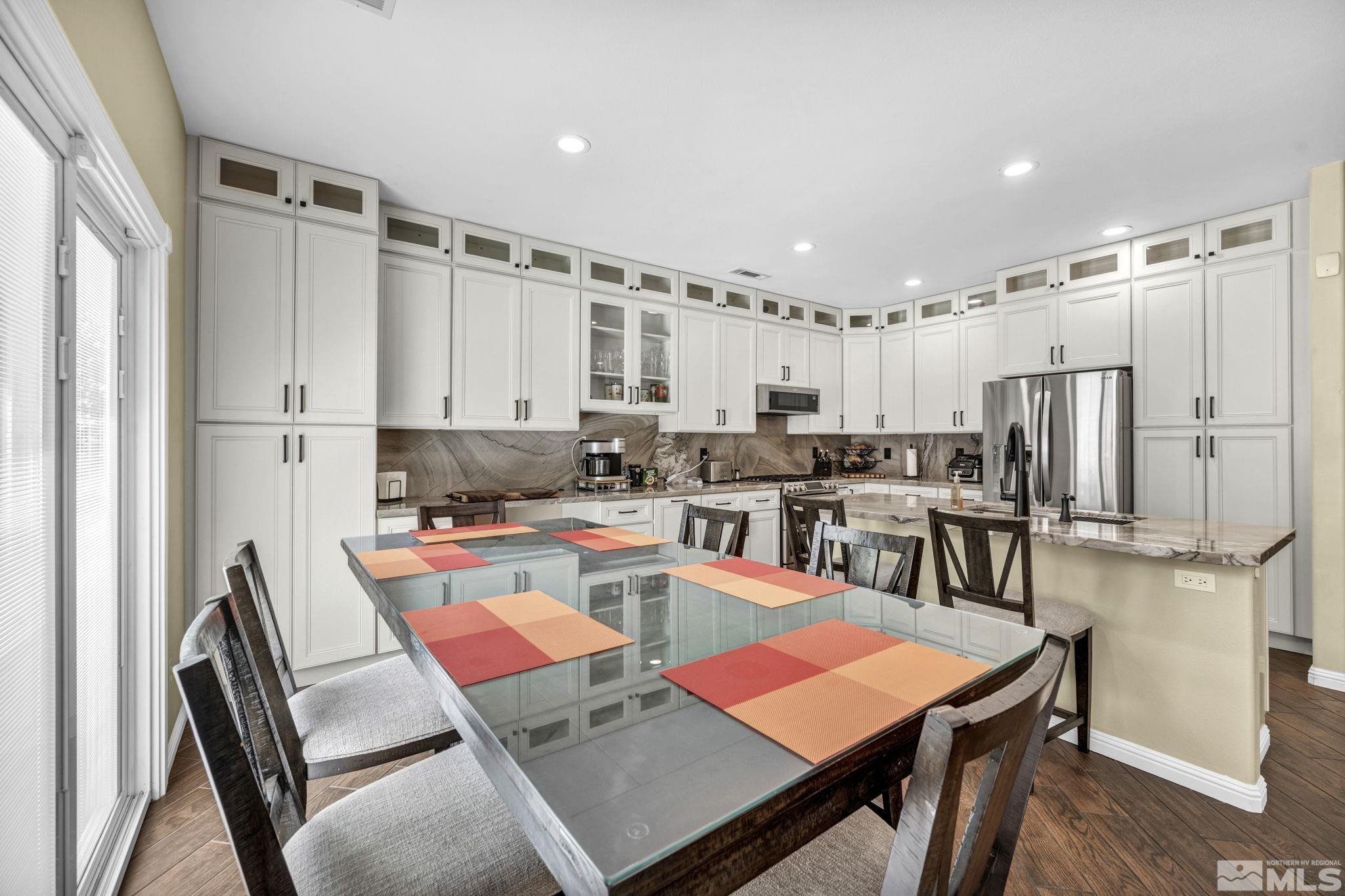 6015 Stillmeadow Drive Reno, NV 89502 - Photo 18 of 39 a kitchen with stainless steel appliances granite countertop a stove a refrigerator a dining table and chairs