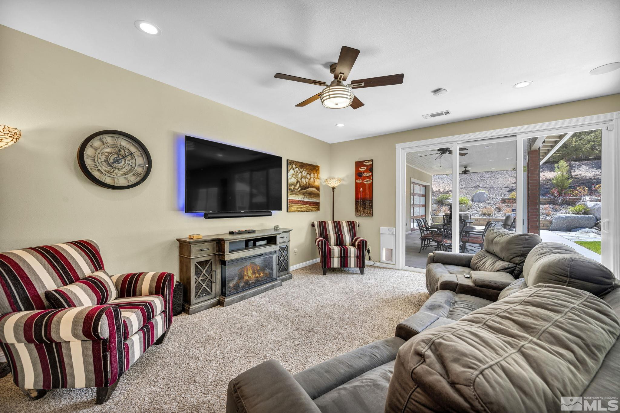 6015 Stillmeadow Drive Reno, NV 89502 - Photo 19 of 39 a living room with furniture a flat screen tv and a large window