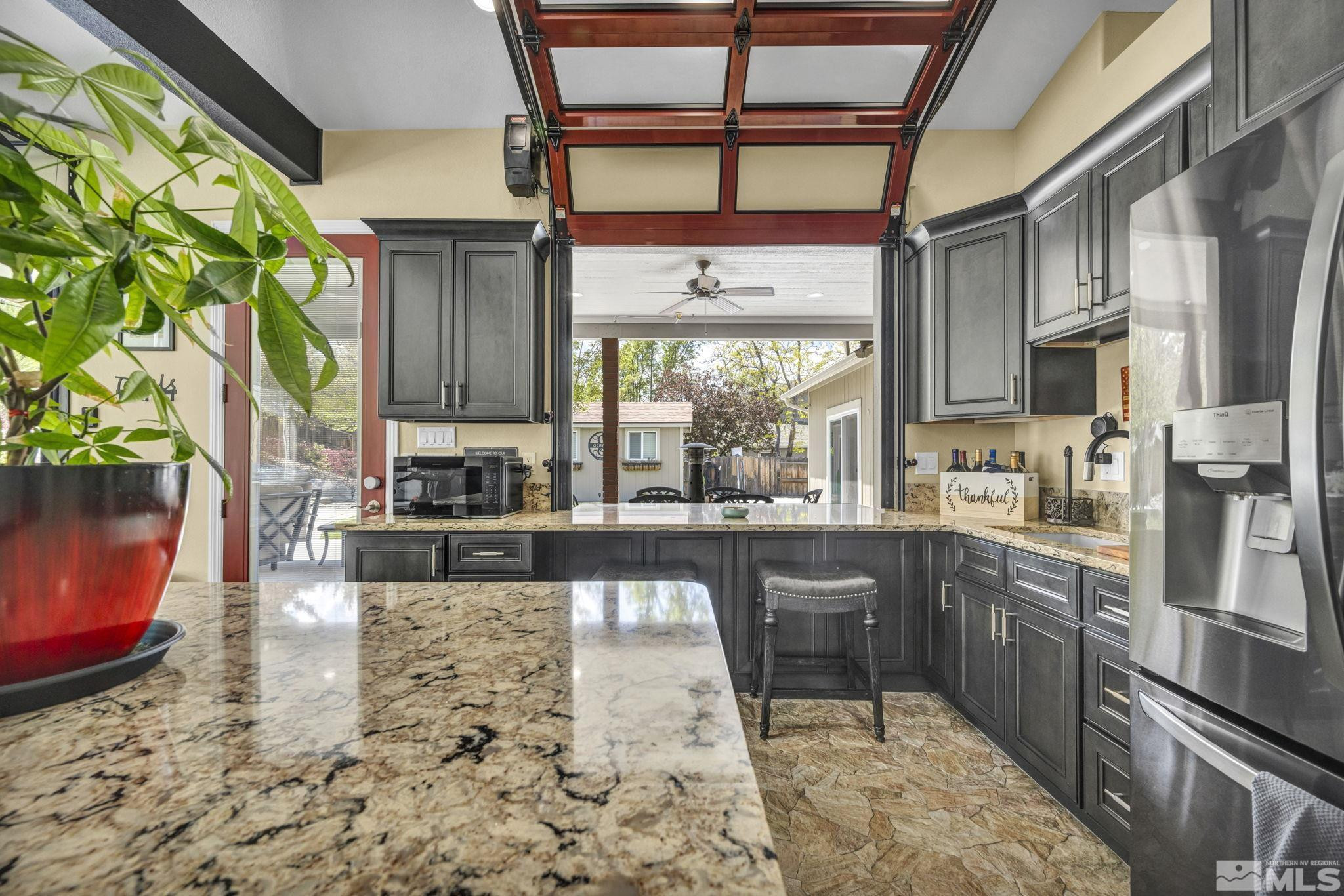 6015 Stillmeadow Drive Reno, NV 89502 - Photo 6 of 39 a kitchen with stainless steel appliances granite countertop a sink a stove and a wooden floors