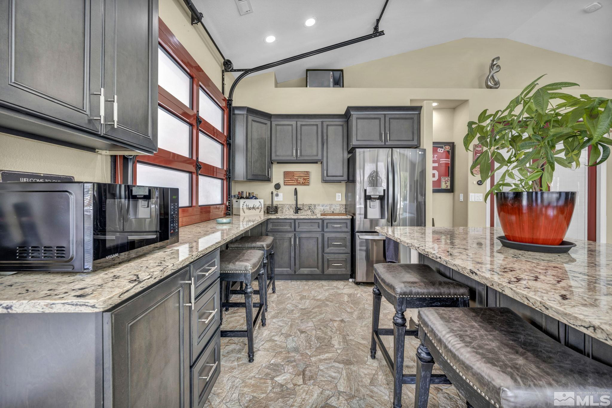 6015 Stillmeadow Drive Reno, NV 89502 - Photo 8 of 39 a kitchen with stainless steel appliances granite countertop a table chairs sink and cabinets