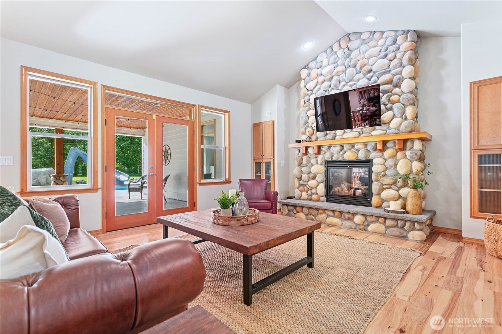 6068 East Hemmi Road Bellingham, WA 98226 - Photo 12 of 40 a living room with furniture a flat screen tv and a fireplace