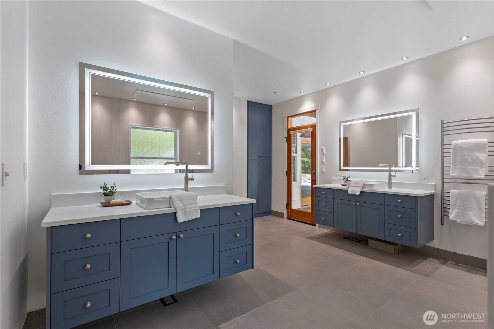 6068 East Hemmi Road Bellingham, WA 98226 - Photo 18 of 40 a spacious bathroom with a double vanity sink a large mirror and a bathtub