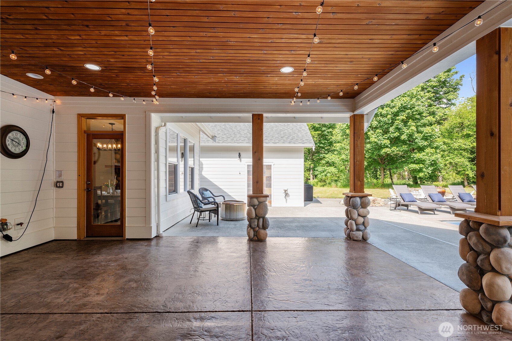6068 East Hemmi Road Bellingham, WA 98226 - Photo 26 of 40 a view of a patio with table and chairs and couches with wooden roof