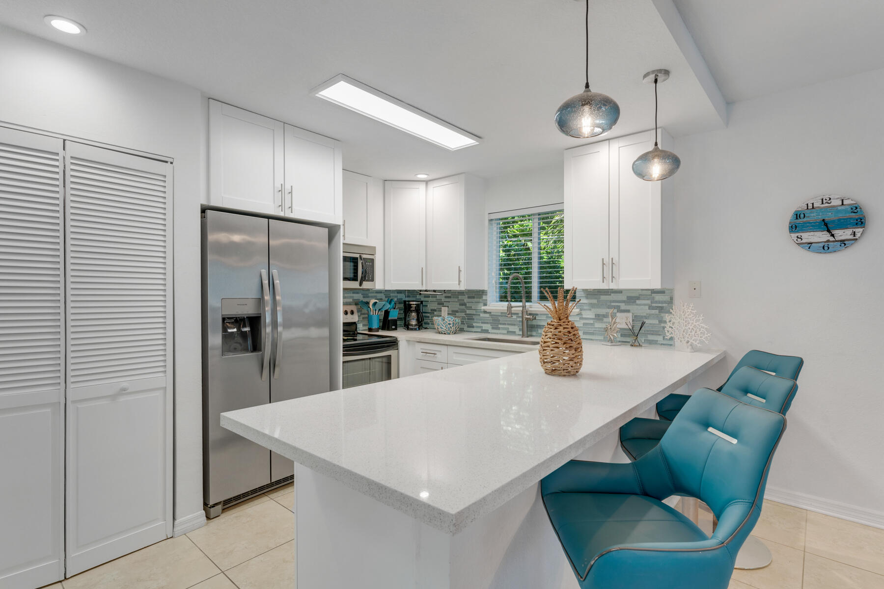 189 Carroll Street Islamorada, FL 33036 - Photo 16 of 37 a kitchen with stainless steel appliances a refrigerator a sink dishwasher a oven with white cabinets and wooden floor