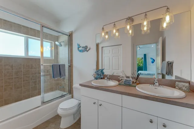 a bathroom with a double vanity sink toilet and shower