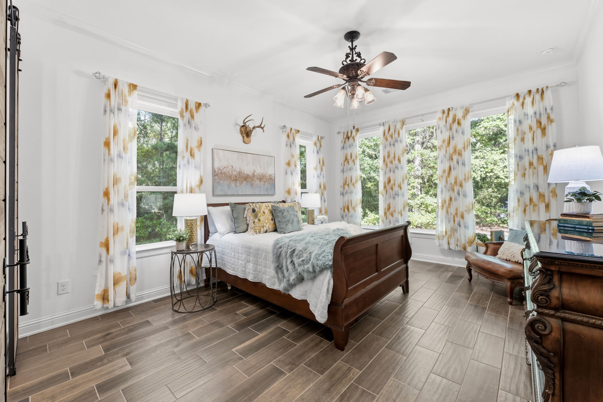 248 Fire Sky Road Huntsville, TX 77340 - Photo 17 of 36 Spacious primary suite with abundant natural light and multiple windows showcasing peaceful views of the wooded backyard.