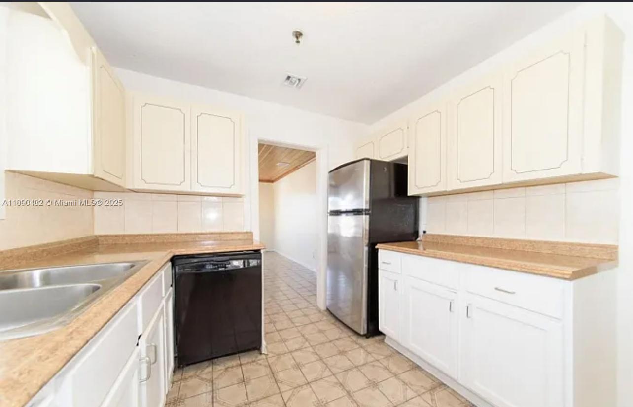 438 Malverne Road, Unit 1 West Palm Beach, FL 33405 - Photo 4 of 12 a kitchen with a sink stove and refrigerator