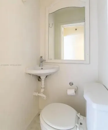 a bathroom with a sink a toilet and mirror