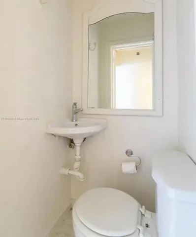 a bathroom with a sink a toilet and mirror