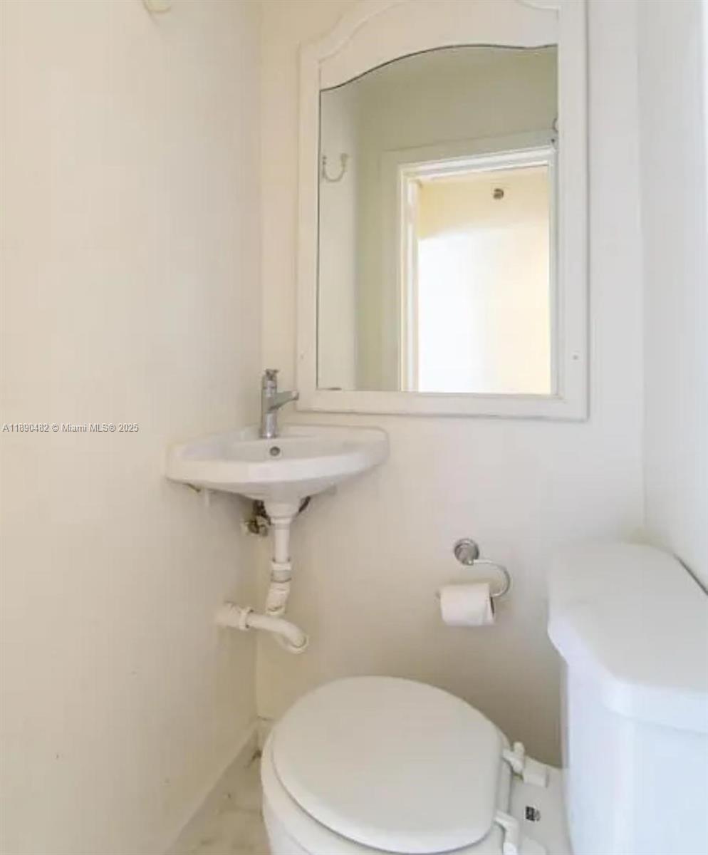 438 Malverne Road, Unit 1 West Palm Beach, FL 33405 - Photo 8 of 12 a bathroom with a sink a toilet and mirror