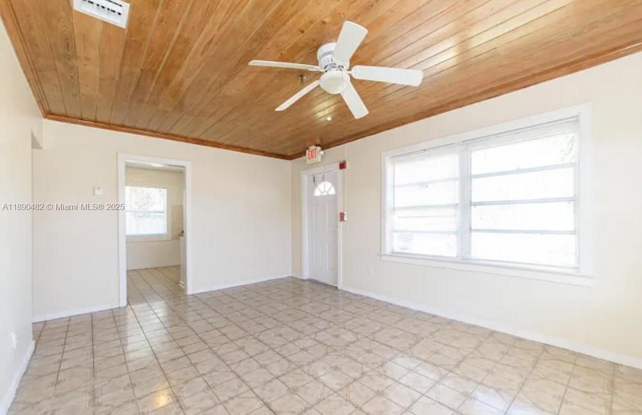 438 Malverne Road, Unit 1 West Palm Beach, FL 33405 - Photo 10 of 12 an empty room with chandelier fan and windows