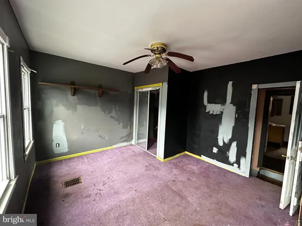 an empty room with window and a ceiling fan