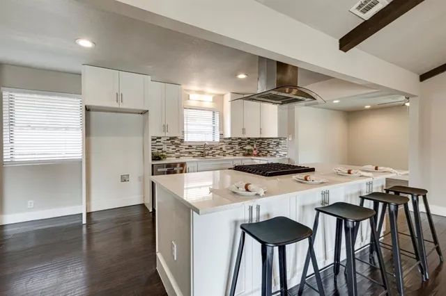 a kitchen with stainless steel appliances a table and chairs in it