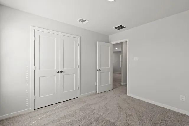 a view of an empty room with closet area