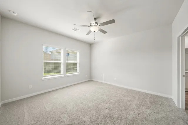 an empty room with windows and fan