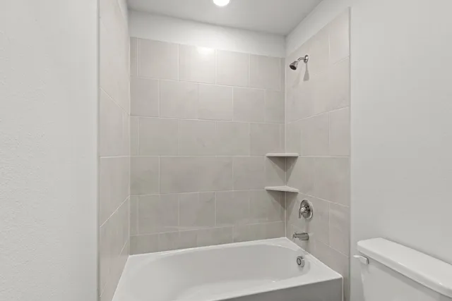 a bathroom with a bathtub and toilet