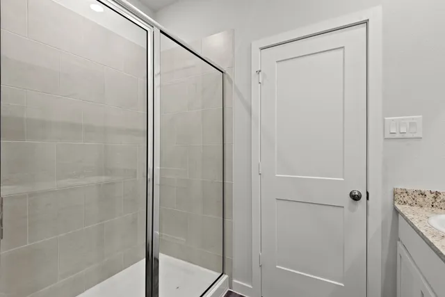 a bathroom with a glass shower door