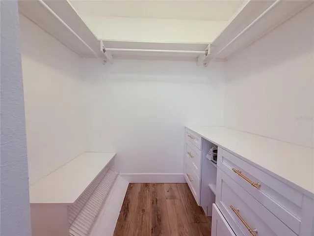 a spacious bedroom with a bed and a dresser