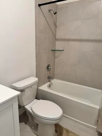a white toilet and tub sitting next to a bathroom sink