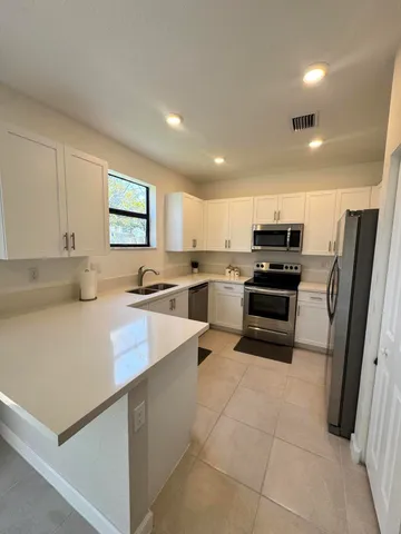 a kitchen with stainless steel appliances a refrigerator sink stove microwave and cabinets