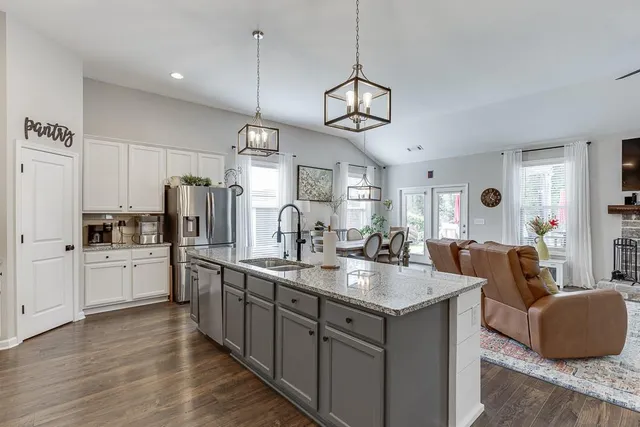 a very nice looking kitchen with a center island wooden floor and stainless steel appliances