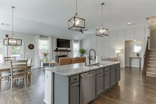 a kitchen with granite countertop a sink a counter space appliances and cabinets