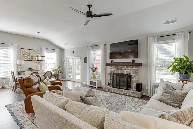 a living room with furniture a flat screen tv and a fireplace
