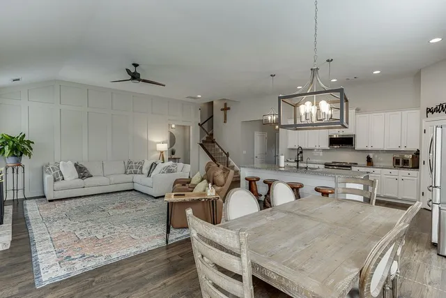 a view of a kitchen with kitchen island stainless steel appliances a sink table and chairs