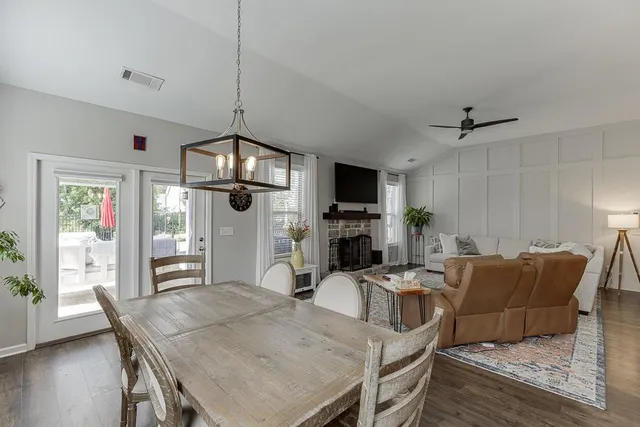 a view of a dining room with furniture a chandelier and wooden floor