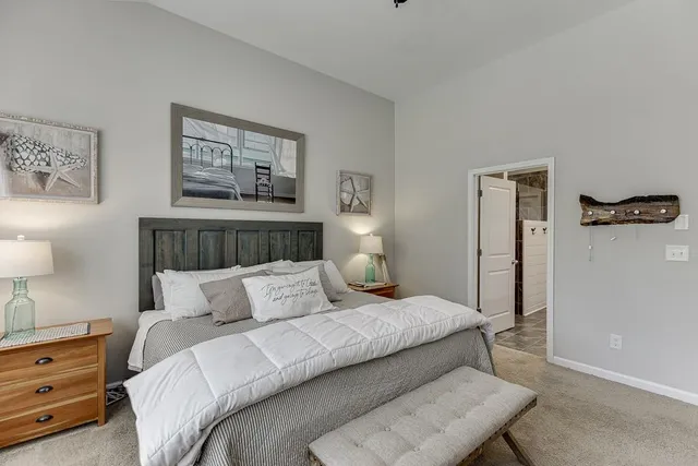 a bedroom with a bed and a lamp on dresser