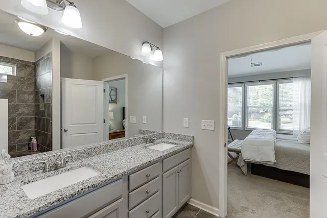 a spacious bathroom with a granite countertop sink and a mirror