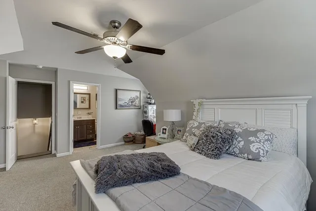 a spacious bedroom with a large bed and a chandelier