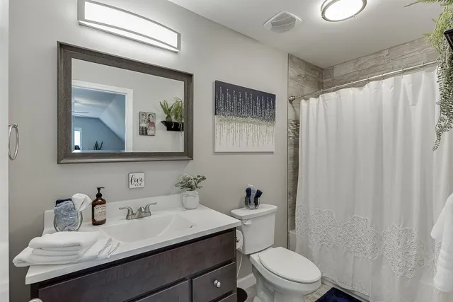 a bathroom with a sink vanity mirror and toilet