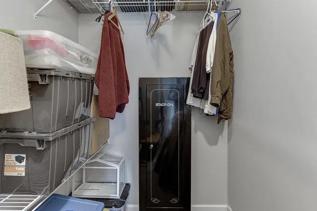 a view of walk in closet with clothes and shoes