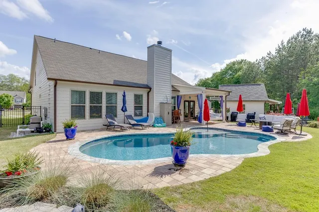 a view of house with swimming pool outdoor seating