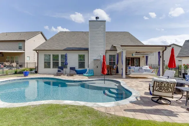 a view of a house with swimming pool and sitting area