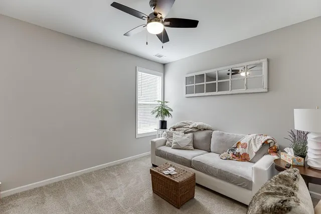 a living room with furniture and a ceiling fan