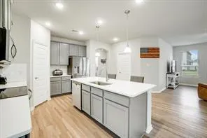 a kitchen with a sink and chairs
