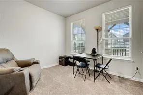 a view of a workspace with furniture and a window