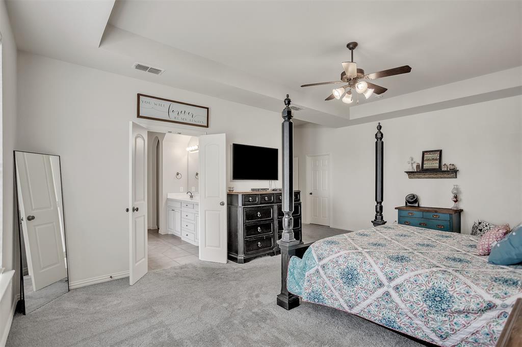 12286 Emerald Ranch Lane North Forney, TX 75126 - Photo 19 of 40 a bedroom with a bed and a flat screen tv