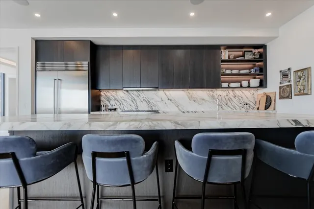 a kitchen with a table chairs refrigerator and cabinets