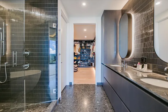 a bathroom with a granite countertop sink a vanity and shower