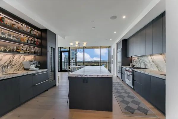 a large kitchen with granite countertop a stove and cabinets