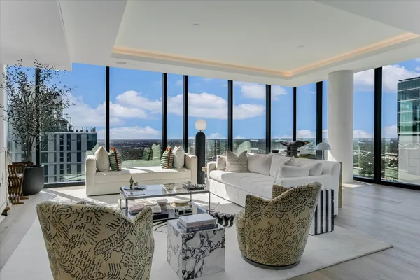 a living room with furniture and large windows
