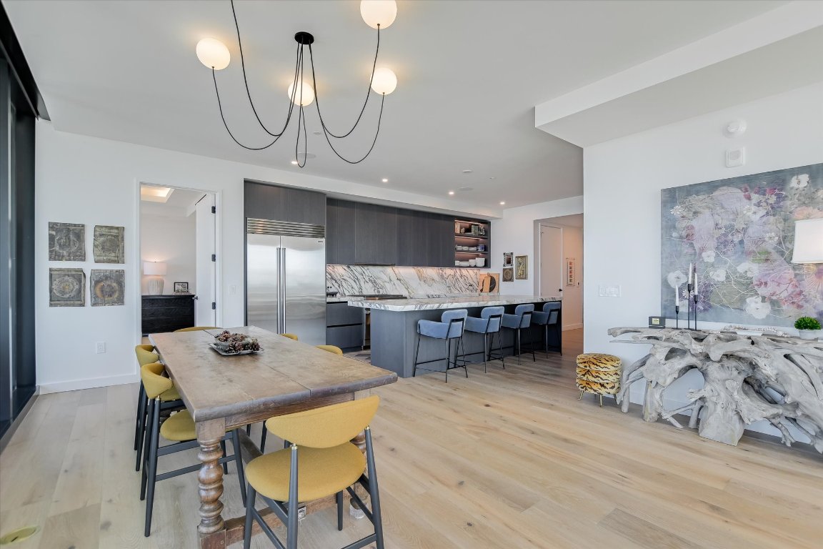 610 Davis Street, Unit 4603 Austin, TX 78701 - Photo 10 of 38 a kitchen with stainless steel appliances a dining table chairs stove refrigerator and cabinets