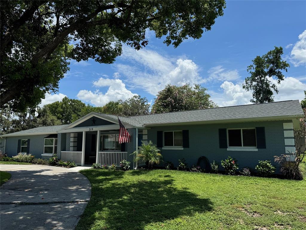 219 Magnolia Circle Eustis, FL 32726 - Photo 1 of 1 a front view of house with a garden and patio